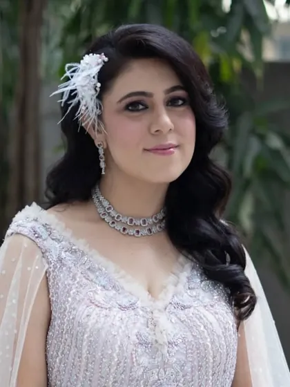The client looking radiant with her vintage-inspired waves and feather accessory. This hairstyle is designed to make you feel confident and glamorous.