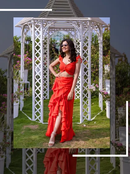 A full-length shot of the red co-ord set against a white gazebo, showing how the color pops.