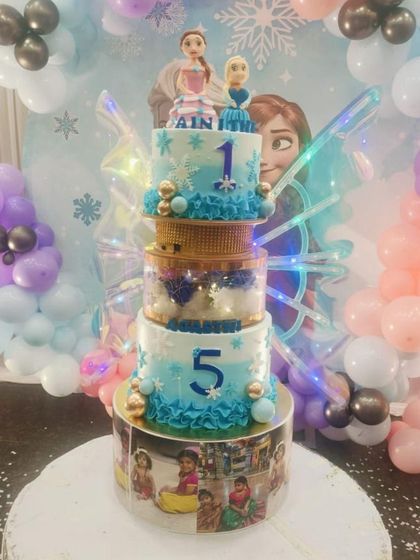 A magical fusion of the viral butterfly wings trend and a classic Frozen theme. This multi-tiered cake features Elsa and Anna figurines, photo panels, and beautiful light-up wings.