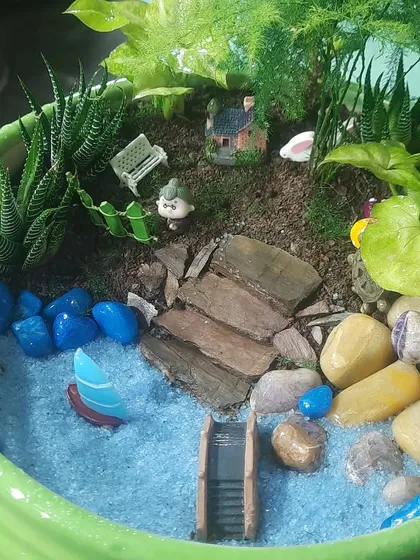 I create tiny worlds in a pot. This custom miniature garden features a variety of succulents, decorative stones, and small figurines, making it a perfect gift or a unique piece for your desk.