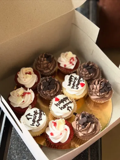 A closer view of the housewarming cupcake assortment, showing the mix of flavors like red velvet with cream cheese frosting and rich chocolate.