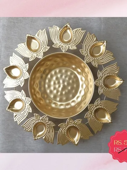 A beautiful golden urli platter with an outer ring of diyas. This piece is on clearance sale and is a fantastic addition to your festive decor collection.