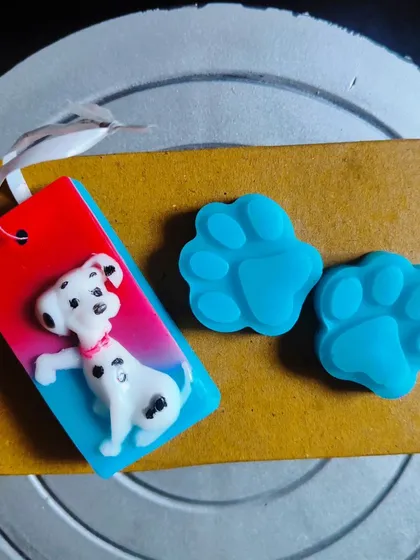 A Dalmatian dog soap with two paw print soaps, perfect for a "101 Dalmatians" or puppy-themed party.