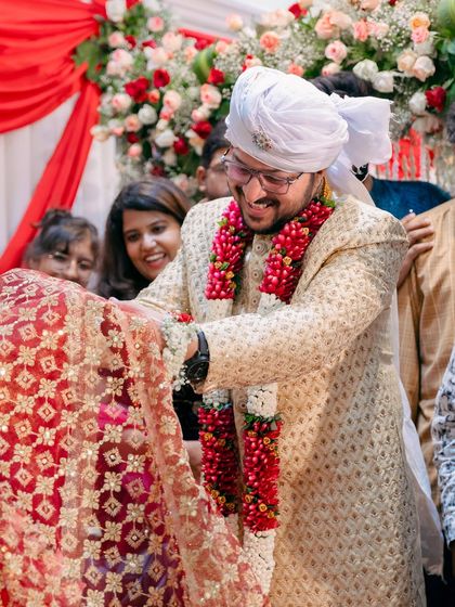 A similar ritual shot from a different angle, showing the groom's happy expression as family looks on.