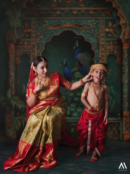 This frame captures the playful and loving relationship between Yashoda and Krishna, set against a backdrop of traditional Indian art.