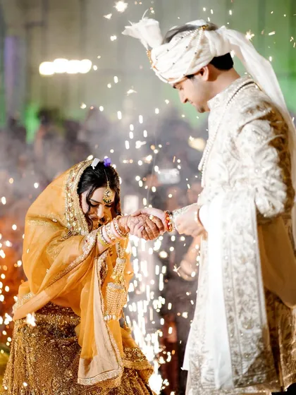 The bride and groom exchange rings amidst a shower of sparklers.