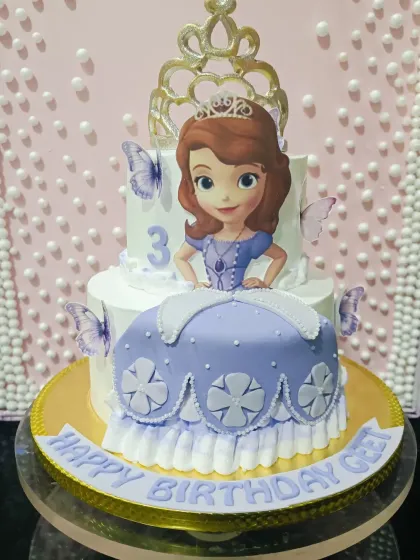 A Princess Sofia the First cake for a 3rd birthday. This two-tiered design features an edible skirt and a character topper, fit for royalty.
