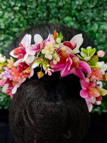 A soft and romantic hair veni with multi-colored pastel flowers, perfect for a daytime event or a whimsical bridal look.