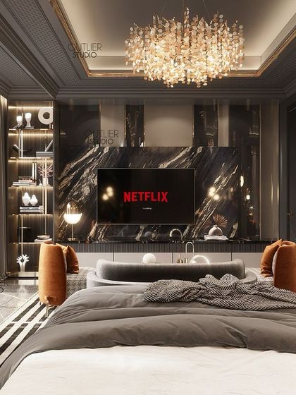 This master bedroom is designed for a lavish, hotel-like experience. A black marble media unit, a grand crystal chandelier, and dark, moody wall paneling create a dramatic and opulent space for relaxation.