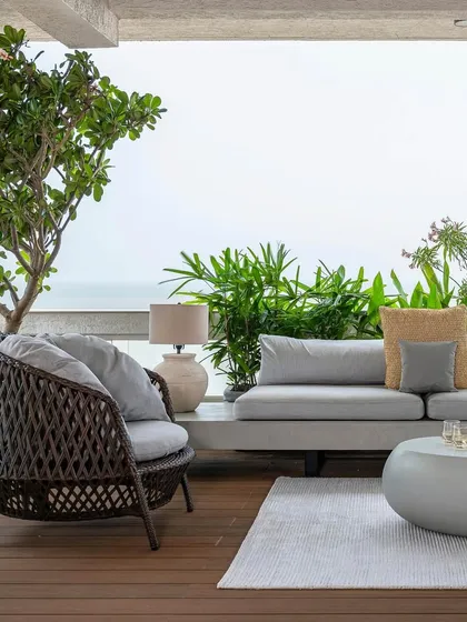 Another view of the sea-facing terrace at Apartment 1600. The design prioritizes comfort and durability, using all-weather wicker armchairs and a low-profile sofa to create a luxurious outdoor living room that feels like a private coastal retreat.