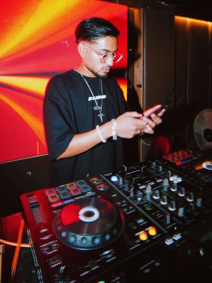 Taking a moment to check requests or coordinate while on the decks. I manage the business of the party while keeping the music flowing.