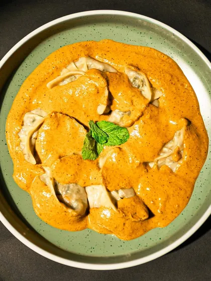Our Jhol Momos are a true taste of the Himalayas. These delicate steamed dumplings are served swimming in a tangy and spicy broth, or 'jhol', made with a base of sesame, garlic, and a hint of mustard oil. The creamy texture of the broth perfectly complements the juicy filling of the momos.