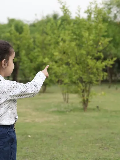 Capturing a child's sense of wonder as they explore their surroundings. This candid shot shows a young boy pointing at something in the distance during our outdoor session.