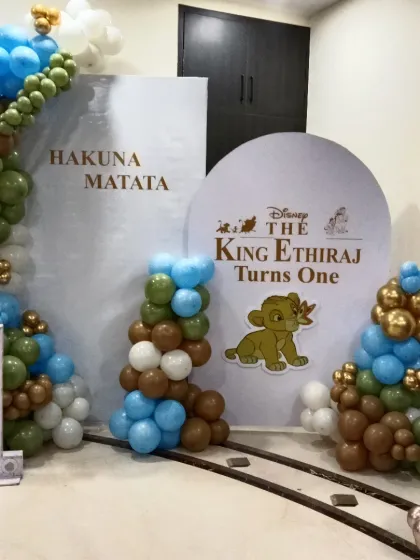 I bring beloved stories to life, like this "Lion King" theme for a first birthday party. The setup includes custom backdrops with "Hakuna Matata," a personalized circular sign, and balloon columns in jungle-inspired colors. The large light-up number '1' makes it clear this is for a milestone celebration.
