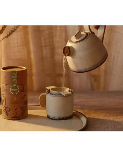 Capturing the quiet ritual of brewing artisanal tea. This image highlights the elegant product packaging while the action of pouring water adds a dynamic, sensory element to the visual story.