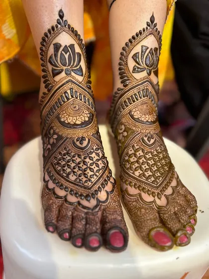 We love creating perfectly symmetrical designs for feet. Here, we've used bold lotus motifs as the centerpiece, surrounded by intricate geometric and traditional patterns that beautifully adorn the feet from ankle to toe.