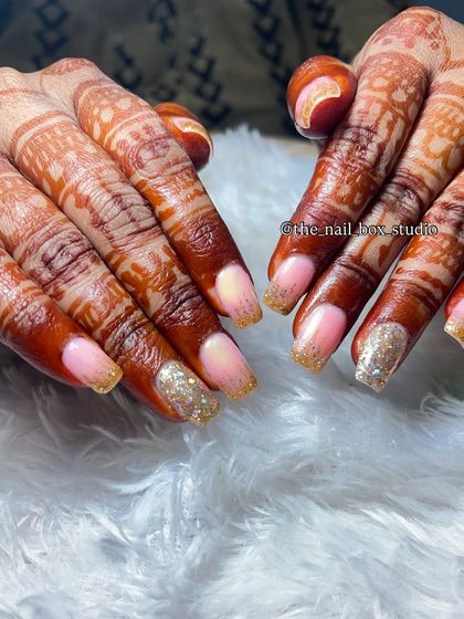 This is a great example of how nail art can enhance hands with mehndi. I used temporary extensions to create a glitter ombré effect with a soft pink base, which makes the nails pop against the dark henna stain.