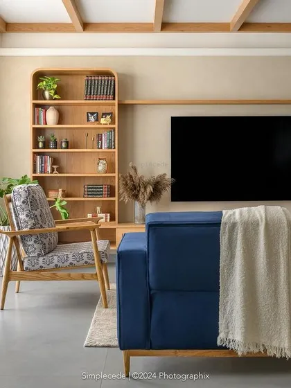 A full view of the 'Cover me in Sunshine' living room, where blue seating punctuates a neutral palette of beige textured walls and charcoal grey flooring.