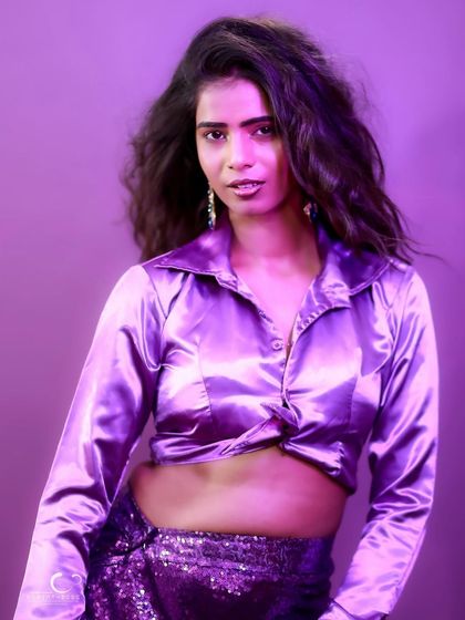 A direct and engaging portrait with a confident gaze. The purple tones create a cool and contemporary mood.