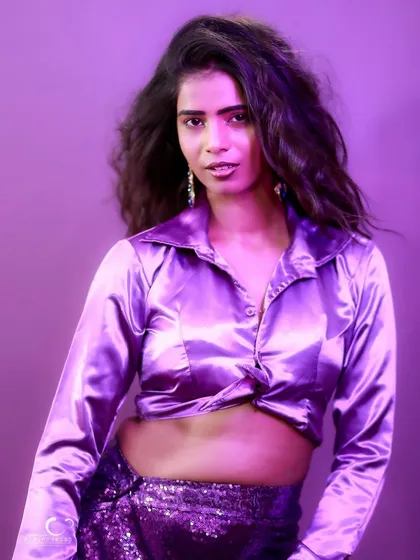 A direct and engaging portrait with a confident gaze. The purple tones create a cool and contemporary mood.
