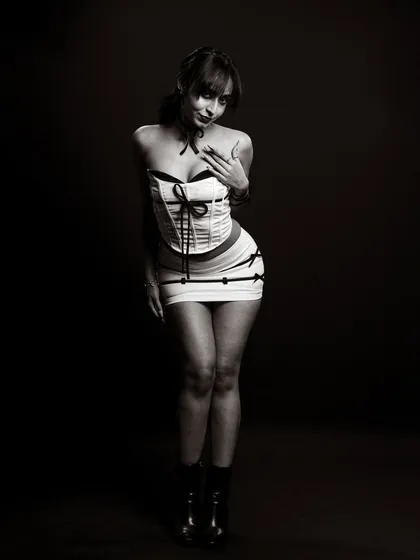 A coy and playful black and white portrait. The pose and expression add a touch of classic pin-up glamour to a model's portfolio.
