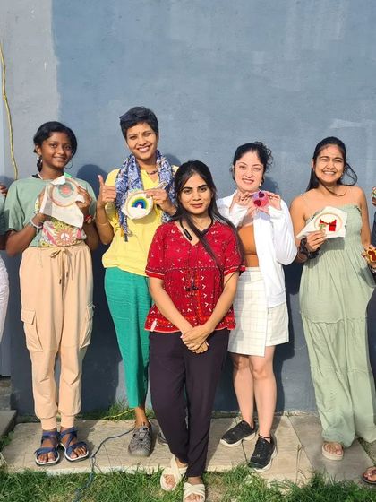 The whole group from a sunny afternoon workshop, proudly displaying their colorful punch needle projects.