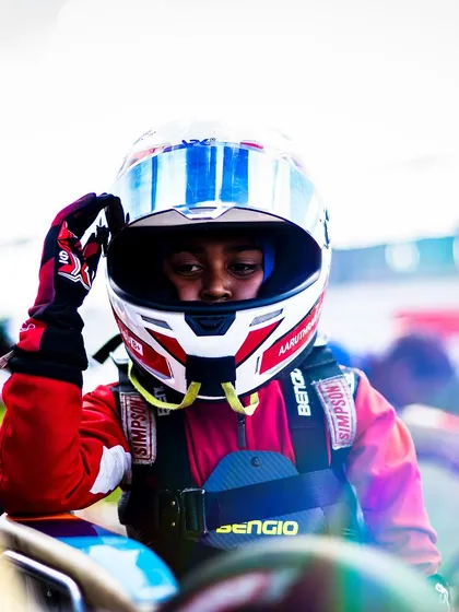 A young driver adjusts his helmet, getting into the zone.