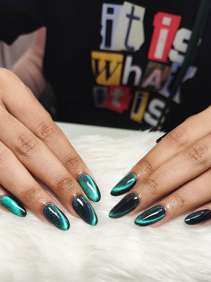Another shot of the stunning emerald green cat-eye nails, showing how the color shifts from deep green to bright teal in the light.