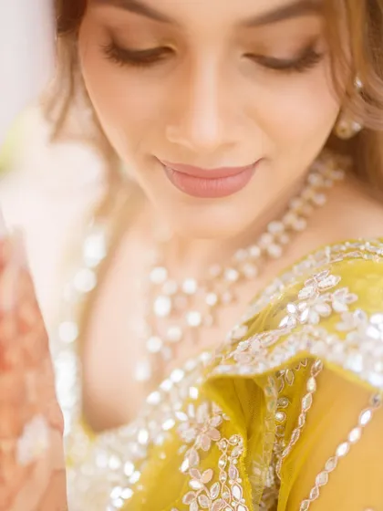 A dreamy, soft-focus shot of the bride's carnival look. The makeup is subtle and glowing, with a focus on her flawless skin.