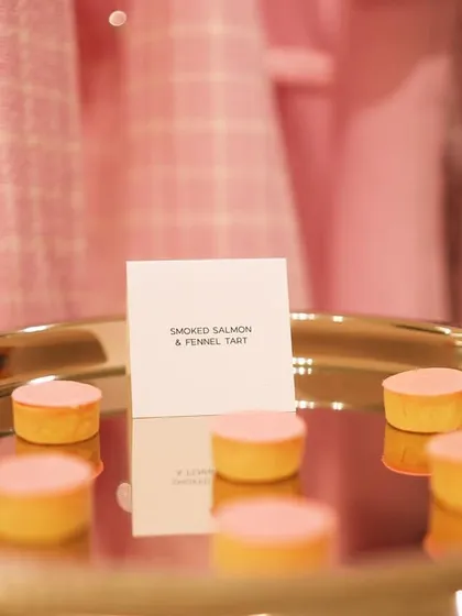 Smoked salmon and fennel tarts with a delicate pink topping, part of a "Colour Story" menu for Versace. The food's color was designed to match the pink hues of the fashion collection in the background.