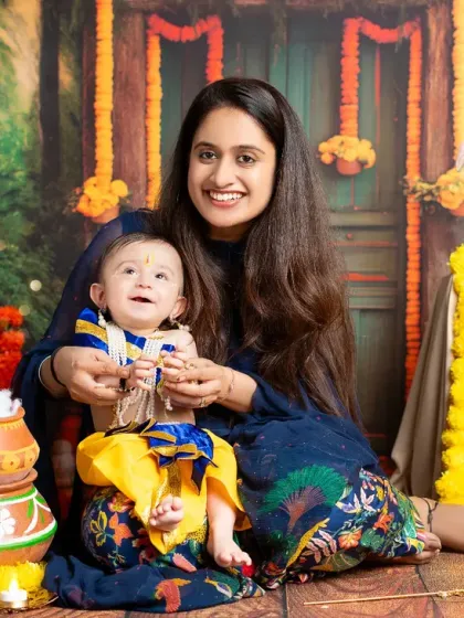 A vibrant and joyful themed photoshoot celebrating a baby's milestone. This custom setup features a colorful Krishna Janmashtami theme, complete with traditional props and a beautifully painted backdrop.