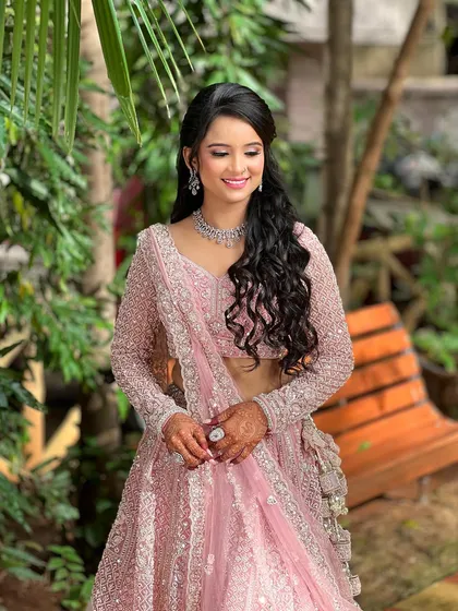 A happy, smiling shot of the bride, looking radiant in her pink engagement outfit and sparkling diamond jewellery.