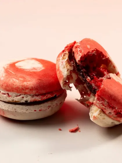 The follow-up shot to the previous image, showing one macaron broken to reveal the delicious filling inside. This "before and after" approach is very effective.