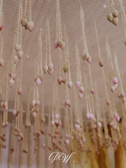 A beautiful detail of hanging lotus buds. This delicate floral installation adds a touch of grace and divinity to the wedding decor.