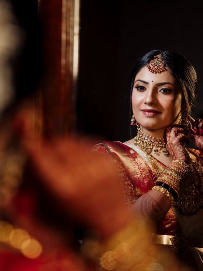 A close-up of a bride getting ready, her reflection caught in a mirror, a beautiful and intimate moment.