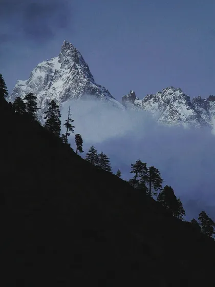 The mountains have secrets. This is a view of a Himalayan peak shrouded in mist, captured in the quiet blue light of dusk. It’s a reminder of the power and peace that I seek in nature.