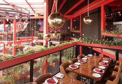 A dining area at Big Pitcher overlooking the lower levels. The integrated planters provide a green buffer, creating a more intimate setting for groups while still feeling connected to the buzz of the venue.