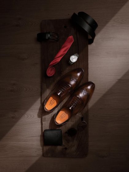 A "what's in my bag" style flat-lay for the modern gentleman. We paired these formal shoes with other essentials like a tie, watch, and wallet.