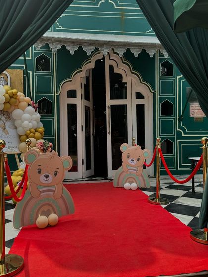 A grand entrance for a teddy bear themed baby shower, featuring a red carpet, velvet ropes, and cute bear cutouts, making guests feel like VIPs.