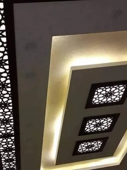 This design uses multiple backlit jali panels of different sizes to create a layered and decorative effect. The clean lines of the surrounding POP structure keep the look modern.