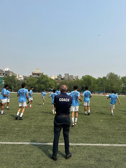 The coach's perspective. Watching over the team during a match day warm-up, ensuring everyone is prepared and focused for the game ahead.