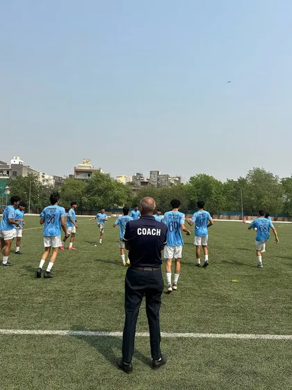 A coach watches over his players during a warm-up. This image captures the guidance and leadership that is central to our training philosophy.
