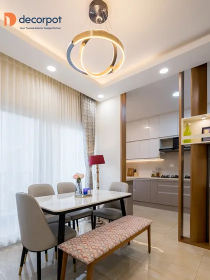 This dining space showcases how a statement pendant light can elevate the entire room. The modern circular chandelier complements the sleek dining table and upholstered bench, creating a sophisticated area for meals.
