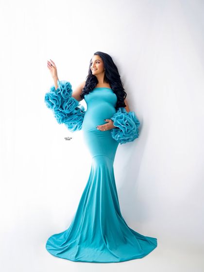 A full-length shot of our aqua blue Rosa gown against a clean white backdrop. This high-key lighting makes the color pop and creates a fresh, airy feel.