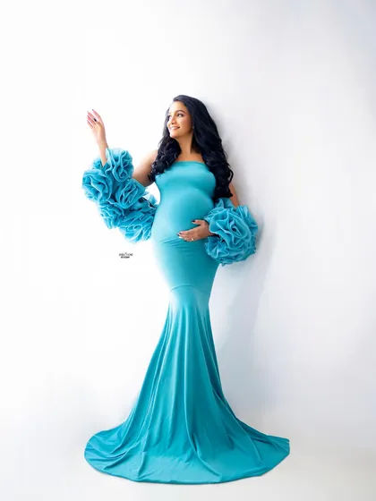 A full-length shot of our aqua blue Rosa gown against a clean white backdrop. This high-key lighting makes the color pop and creates a fresh, airy feel.