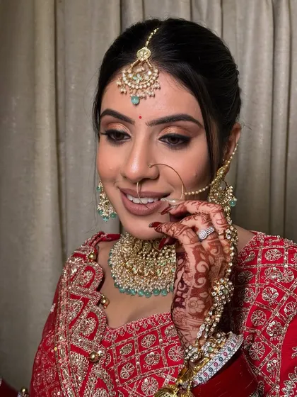 A close-up of this bride's happy smile. Her makeup features a soft brown smokey eye and a nude-pink lip, a modern take on the classic red bridal look.