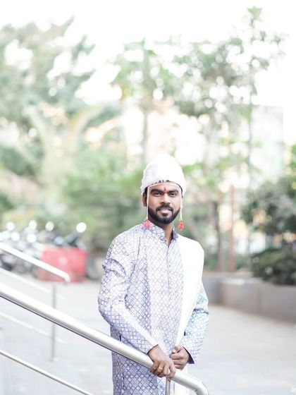A classic portrait of the groom, looking directly at the camera with a confident smile.