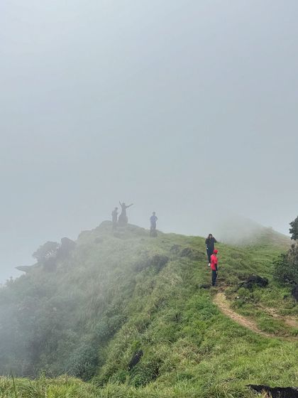 Trekkers making their way up a misty ridge on Kumara Parvatha. The landscape often feels like walking in the clouds.