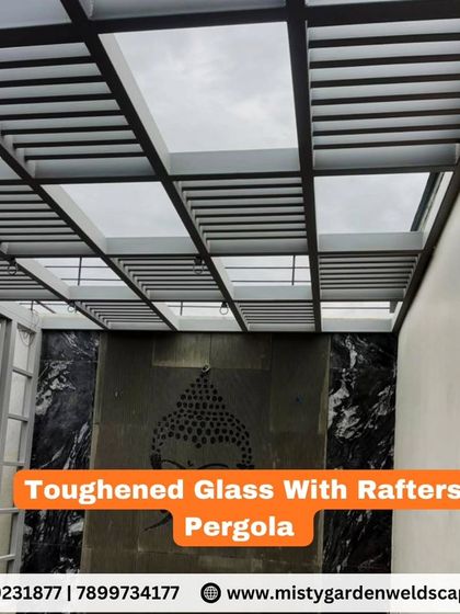 An example of a toughened glass with rafters pergola. The rafters provide additional structural support and an aesthetic pattern, making this a robust and stylish option for modern homes.