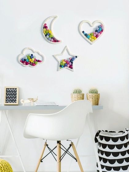 Here you can see how my pom-pom art pieces look in a styled room. The moon, heart, cloud, and star shapes add a touch of modern, handmade charm to this clean and bright workspace.